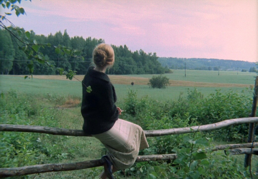 "Зеркало" (1974). Маргарита Терехова с сигаретой смотрит вдаль, сидя на заборчике.